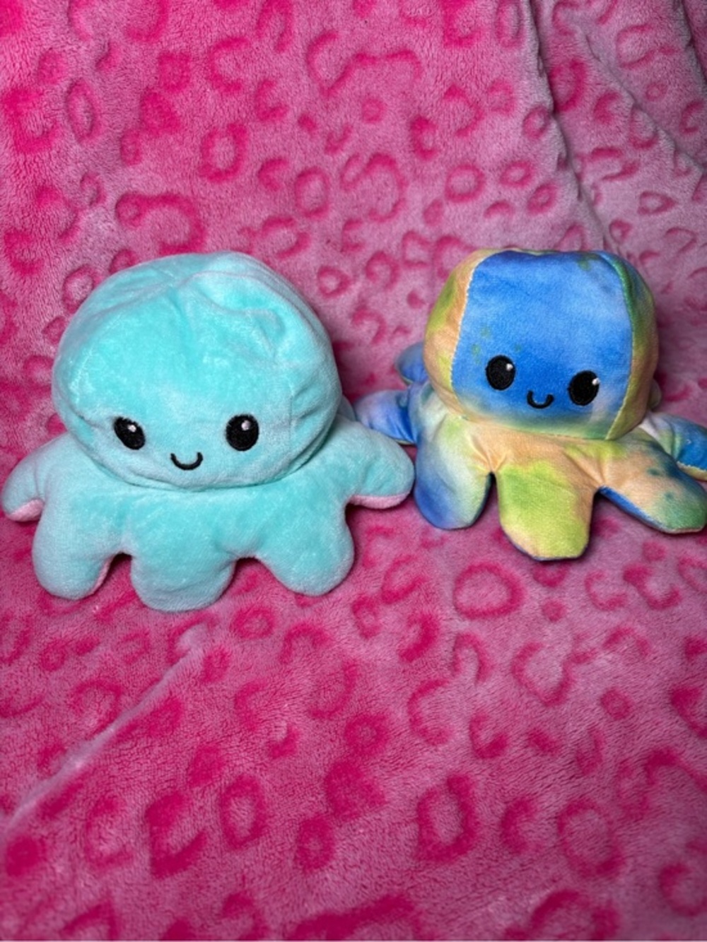 Two reversible mood octopus plushies